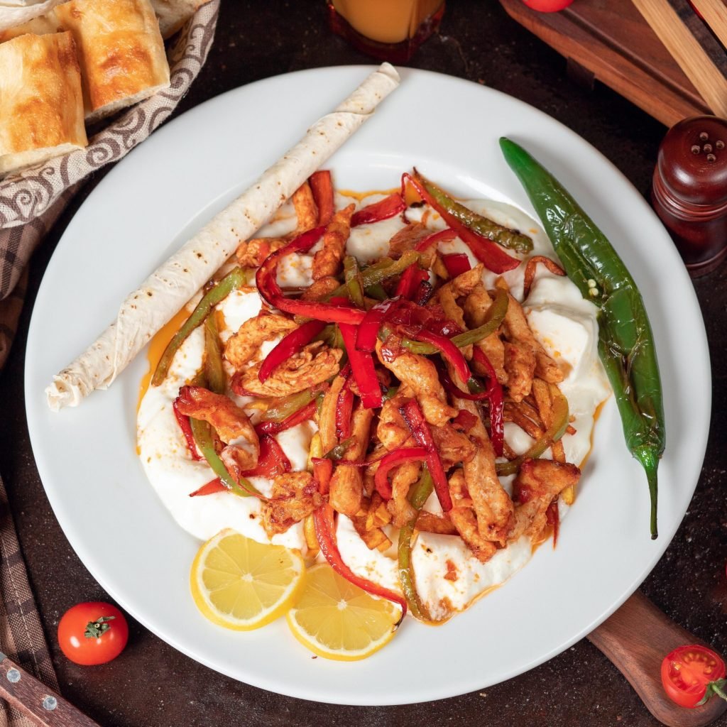 chicken-fajita-chicken-fillet-fried-with-bell-pepper-lavash-with-bread-slices-white-plate